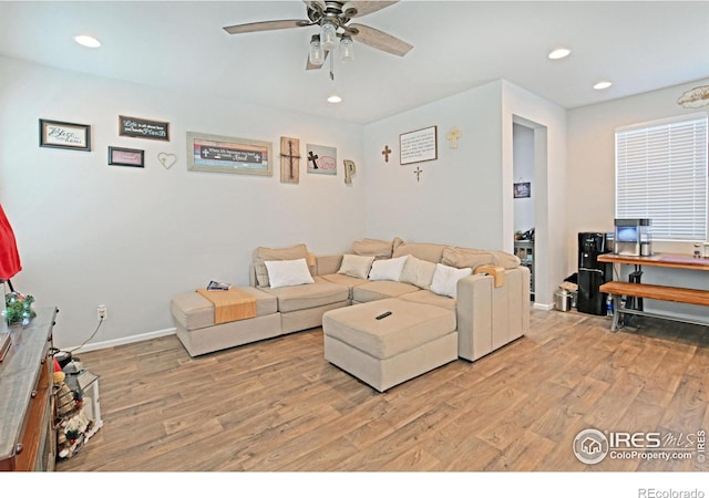 living room featuring light hardwood / wood-style flooring and ceiling fan