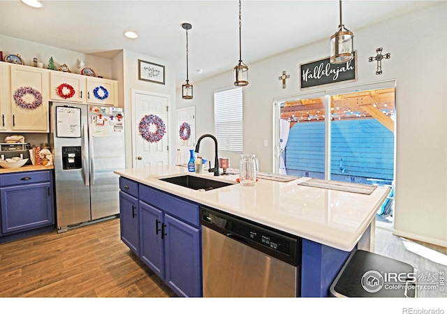 kitchen featuring hardwood / wood-style floors, appliances with stainless steel finishes, sink, and blue cabinetry