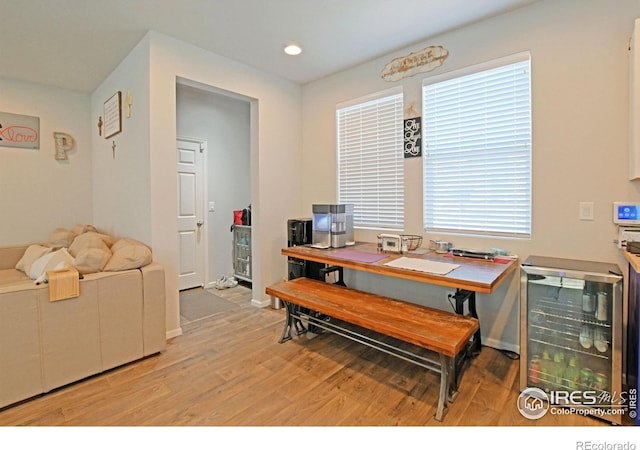 dining area with light hardwood / wood-style flooring and beverage cooler