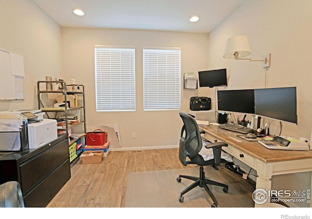 home office with light hardwood / wood-style flooring