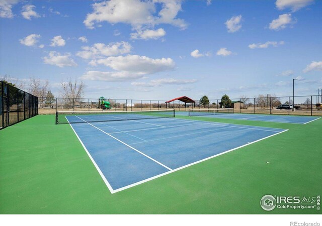 view of tennis court featuring basketball hoop