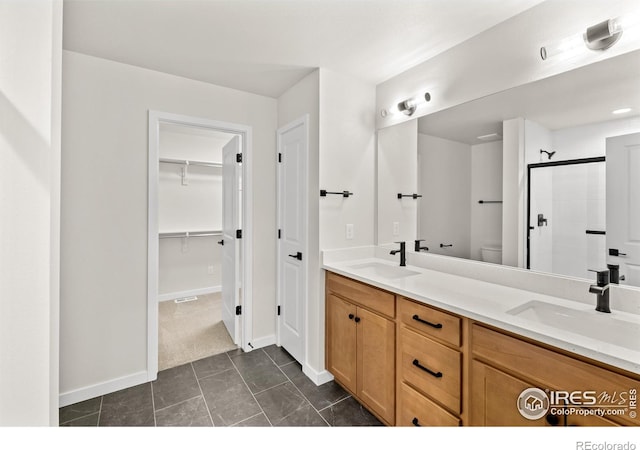 bathroom featuring tile patterned floors, vanity, toilet, and walk in shower