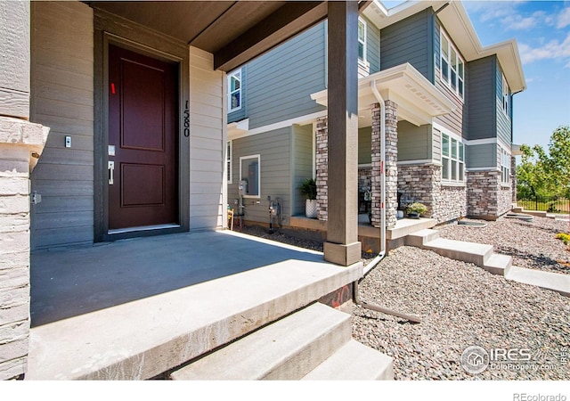 view of exterior entry featuring covered porch