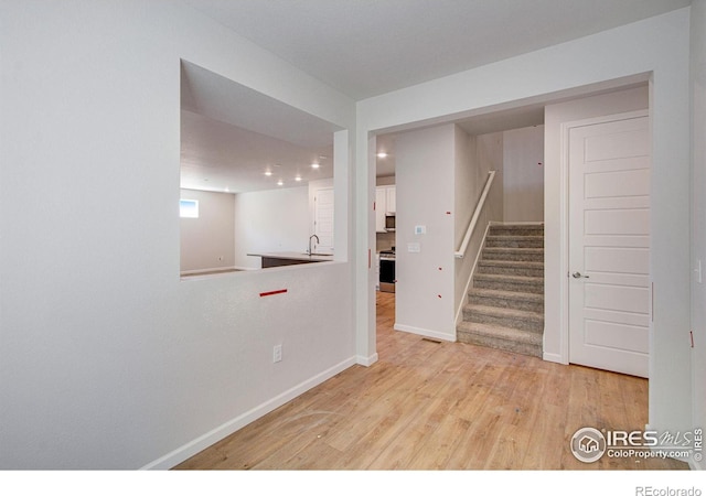 unfurnished room featuring light hardwood / wood-style flooring and sink