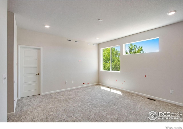 carpeted spare room featuring a textured ceiling