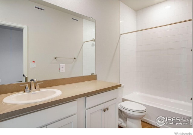 full bathroom with toilet, tiled shower / bath combo, and vanity