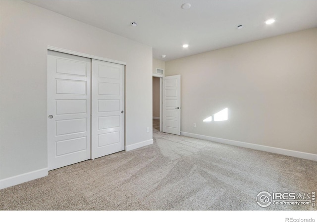 unfurnished bedroom featuring carpet floors and a closet