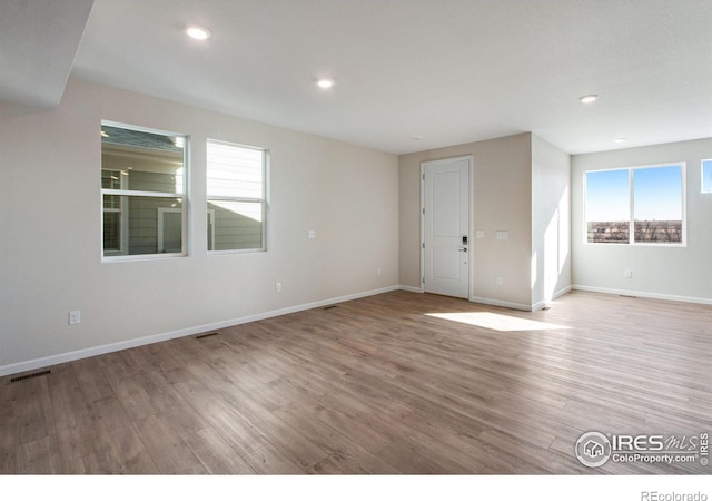 unfurnished room featuring a healthy amount of sunlight and light hardwood / wood-style flooring