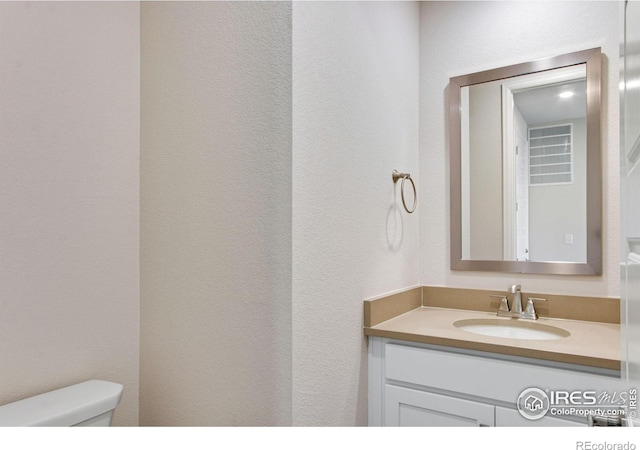 bathroom featuring vanity and toilet