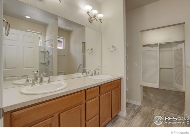 bathroom with walk in shower, vanity, toilet, and wood-type flooring