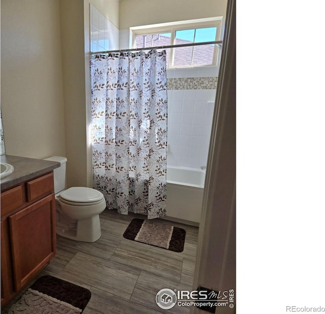 full bathroom featuring shower / bath combo with shower curtain, vanity, and toilet