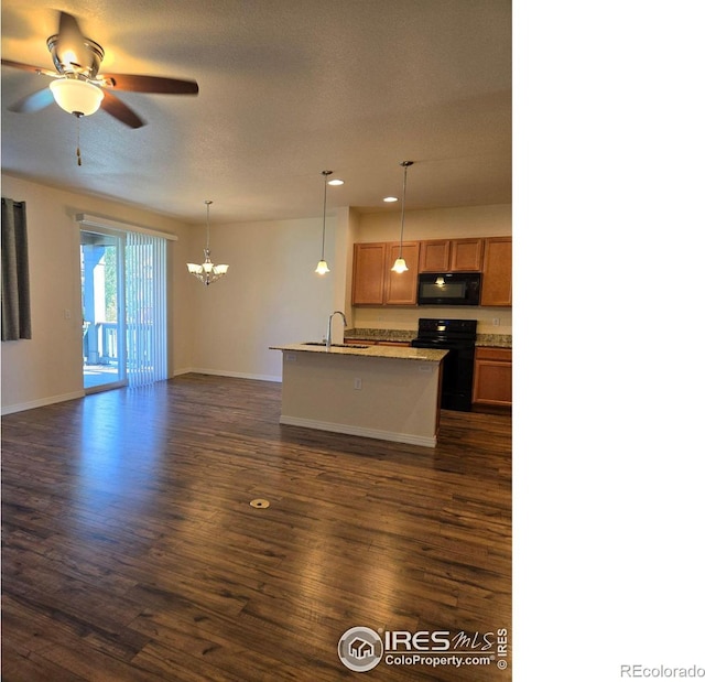 kitchen featuring hanging light fixtures, sink, a center island with sink, black appliances, and dark hardwood / wood-style floors