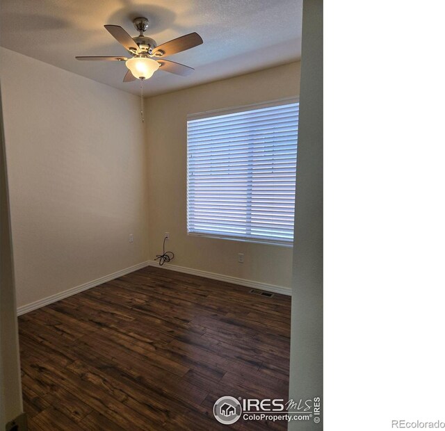 empty room with ceiling fan and dark wood-type flooring