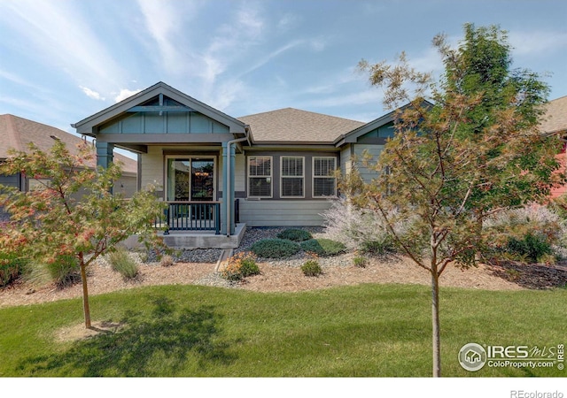 view of front of property with covered porch and a front yard