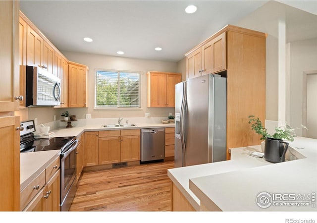 kitchen featuring light brown cabinets, appliances with stainless steel finishes, light wood-type flooring, and sink