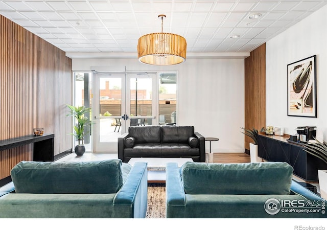 living room featuring wooden walls and french doors