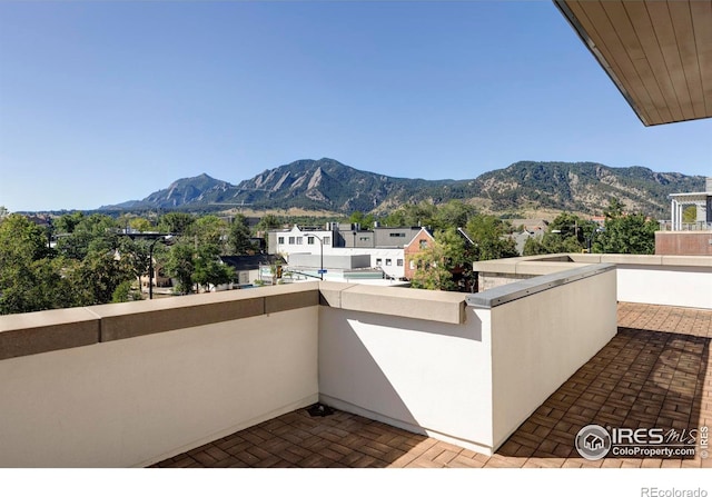 view of patio featuring a balcony and a mountain view