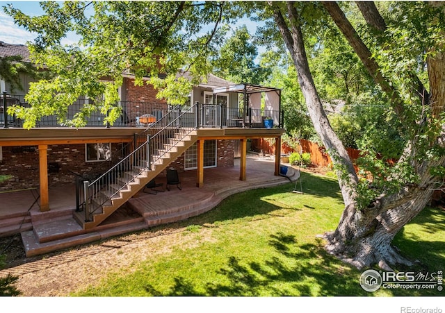 exterior space featuring a wooden deck, a lawn, and a patio