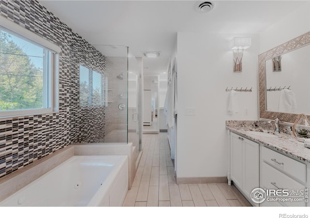 bathroom with shower with separate bathtub and vanity