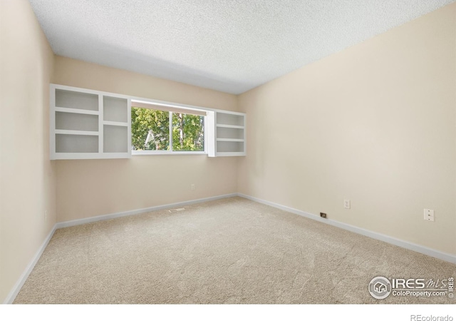 empty room featuring a textured ceiling and carpet