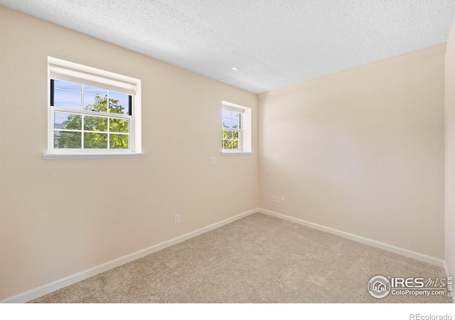 carpeted empty room featuring a textured ceiling