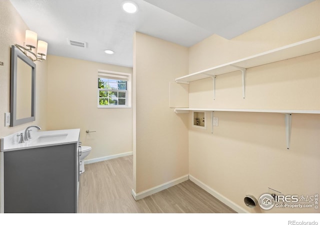 laundry room featuring light hardwood / wood-style flooring, hookup for a washing machine, and sink