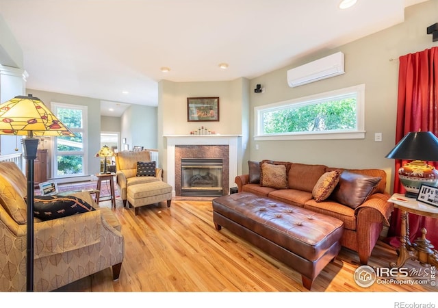 living room with light wood-type flooring, a wall mounted air conditioner, and a fireplace