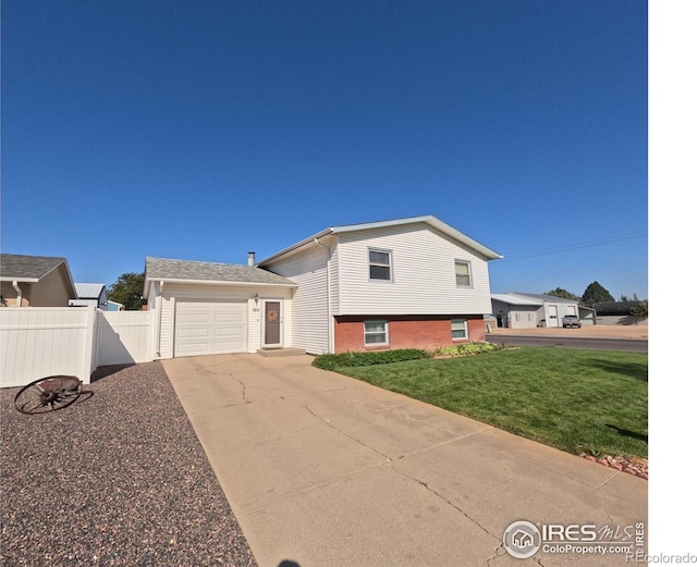 split level home featuring a garage and a front lawn