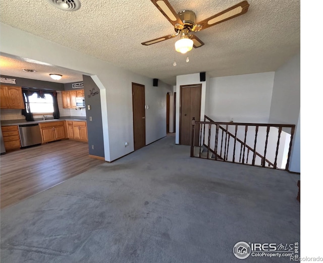 unfurnished living room with a textured ceiling and dark colored carpet