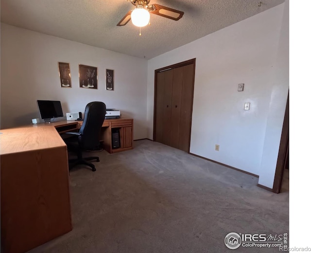 carpeted home office with ceiling fan and a textured ceiling