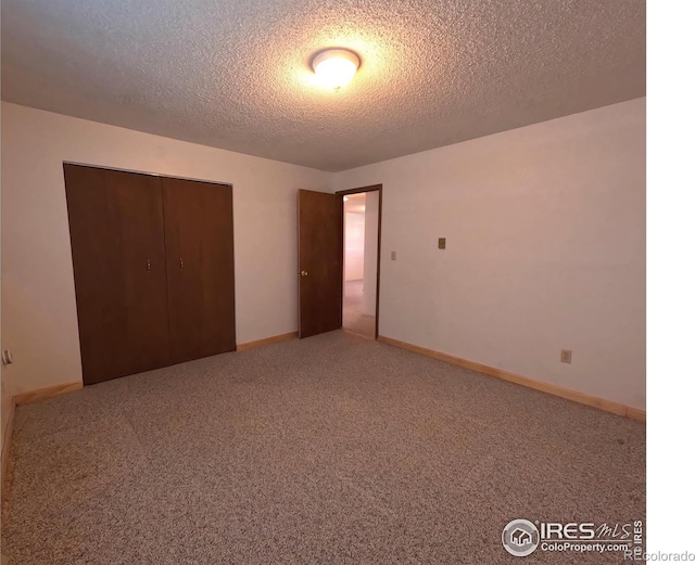 unfurnished bedroom featuring a closet, a textured ceiling, and carpet