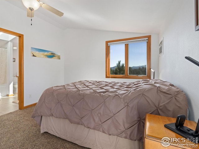 bedroom featuring lofted ceiling, a ceiling fan, carpet flooring, ensuite bath, and baseboards