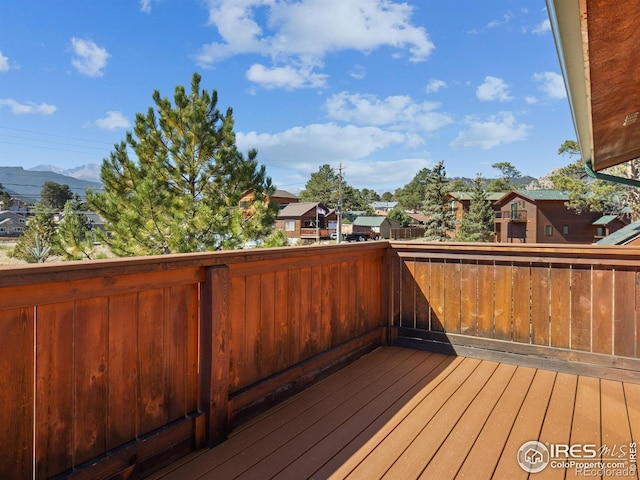 wooden deck with a residential view and a mountain view