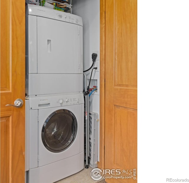 laundry room featuring stacked washer / drying machine and laundry area