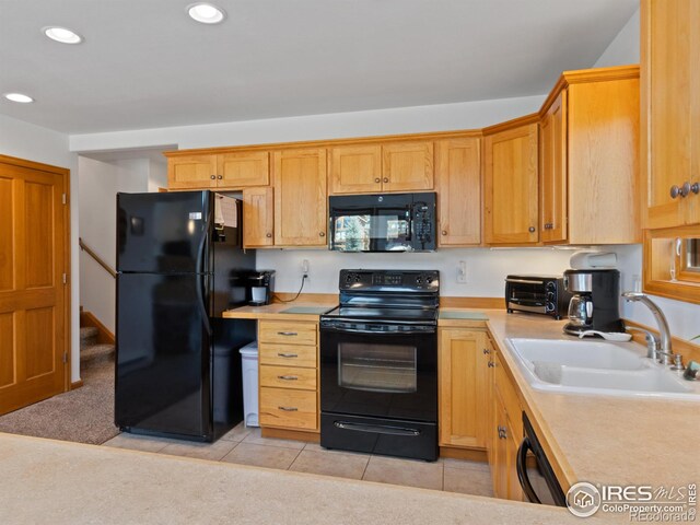 kitchen featuring black appliances, sink, and light tile patterned flooring