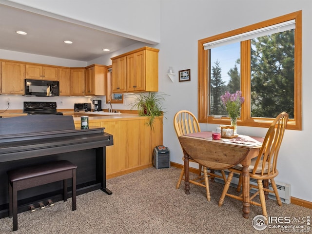 kitchen featuring recessed lighting, light countertops, a sink, black appliances, and baseboards