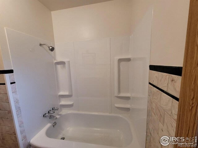 bathroom with tile walls and bathtub / shower combination