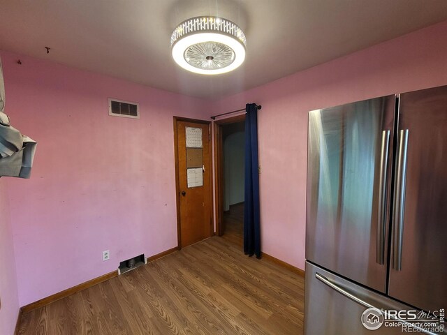 interior space with hardwood / wood-style floors and stainless steel refrigerator