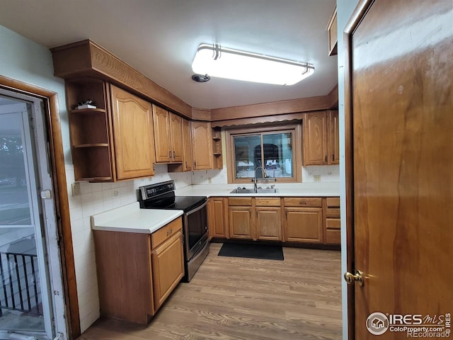 kitchen featuring tasteful backsplash, stainless steel electric stove, light hardwood / wood-style flooring, and sink