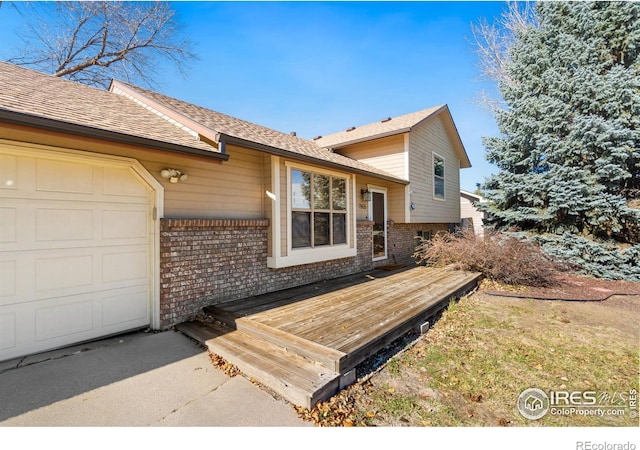 exterior space with a garage and a wooden deck