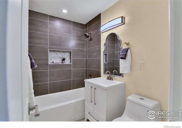 full bathroom featuring toilet, tiled shower / bath combo, and vanity