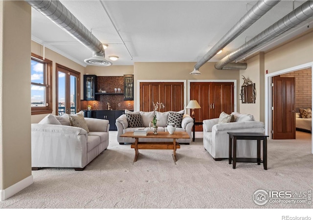 carpeted living room featuring bar area