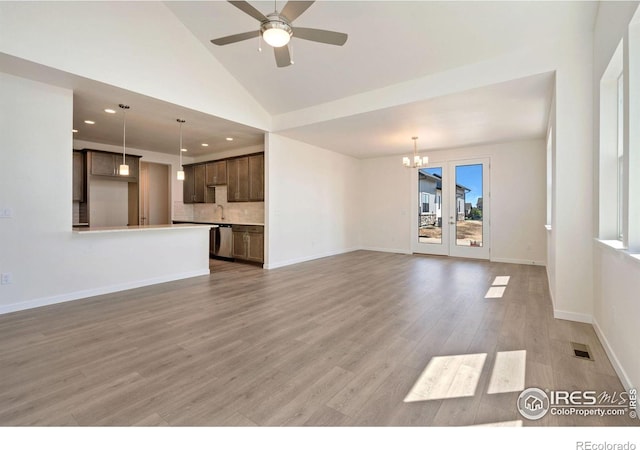 unfurnished living room featuring light wood finished floors, recessed lighting, visible vents, baseboards, and ceiling fan with notable chandelier