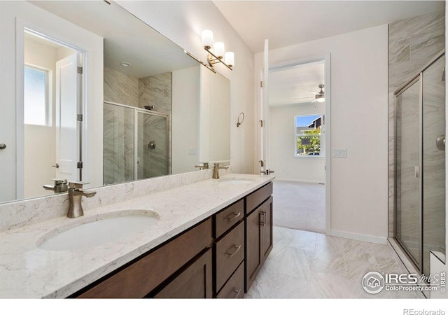 bathroom featuring double vanity, a stall shower, baseboards, and a sink