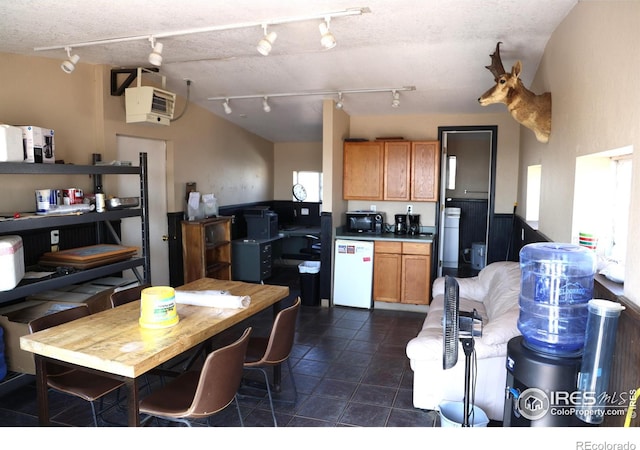 kitchen featuring a textured ceiling, plenty of natural light, and dark tile patterned floors