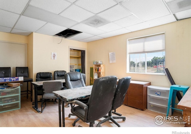 office area with a paneled ceiling and light hardwood / wood-style floors