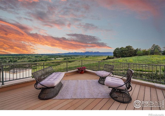 deck at dusk featuring a mountain view