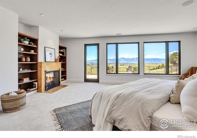 bedroom featuring a mountain view, light carpet, and access to outside