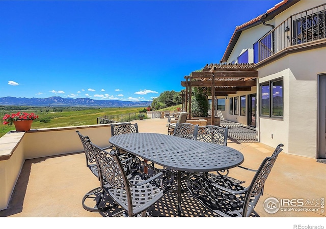 view of patio featuring a pergola, a mountain view, and a balcony