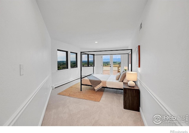 bedroom featuring light colored carpet, french doors, and a baseboard radiator